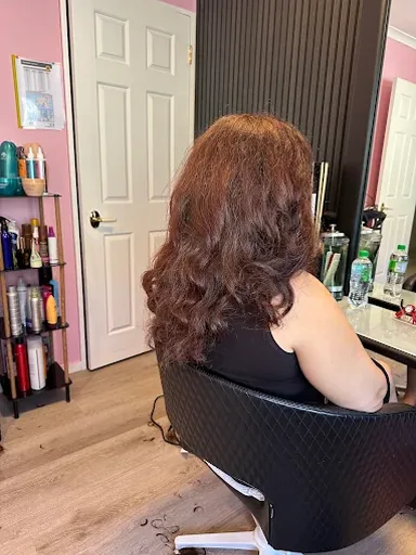 Shoulder-length auburn hair cut in layers and styled in loose curls