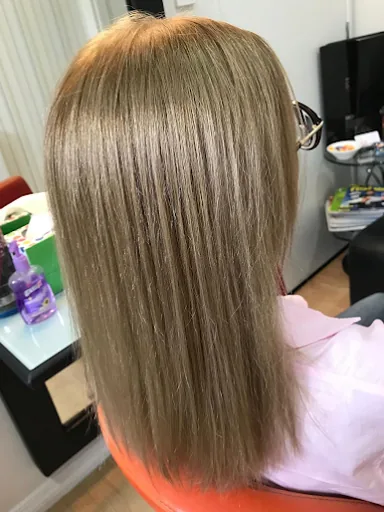 Sleek ash blonde hair, straight and glossy, cut to the shoulders
