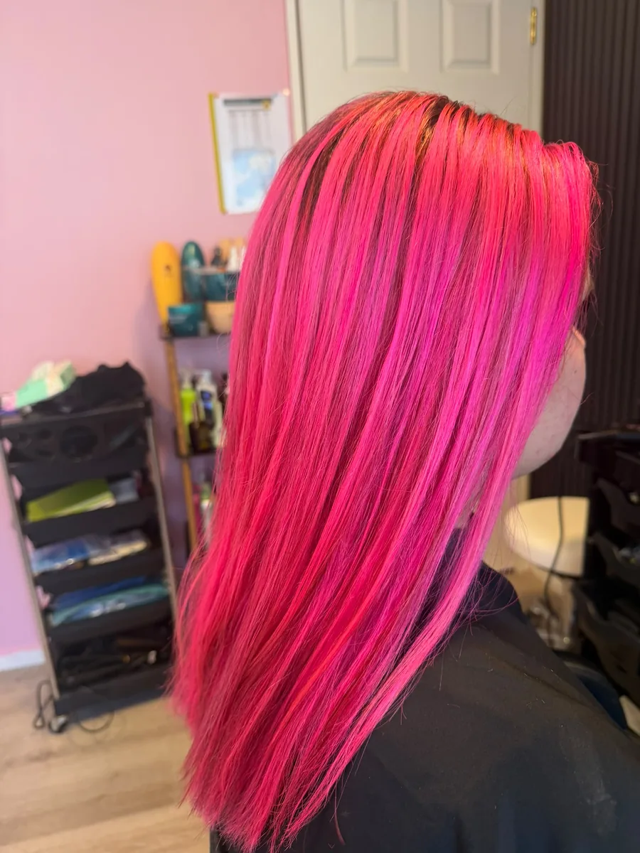 Long straight hair coloured a vivid, glossy hot pink from root to tip